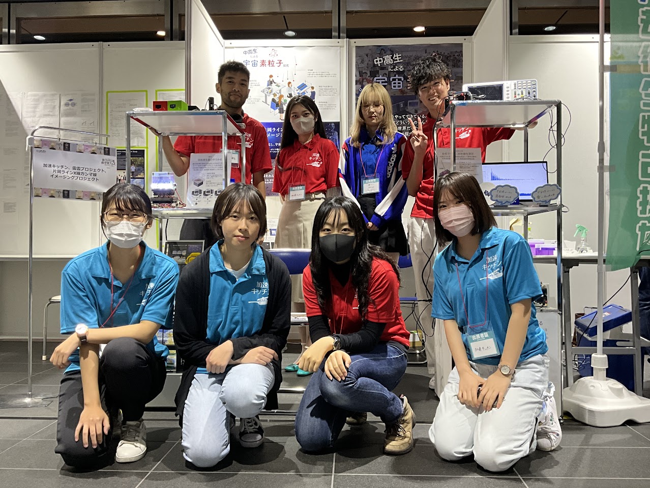 会いに行ける科学者フェスの加速キッチンブース前に並ぶ、おそろいのポロシャツを着た中高生・大学生スタッフ