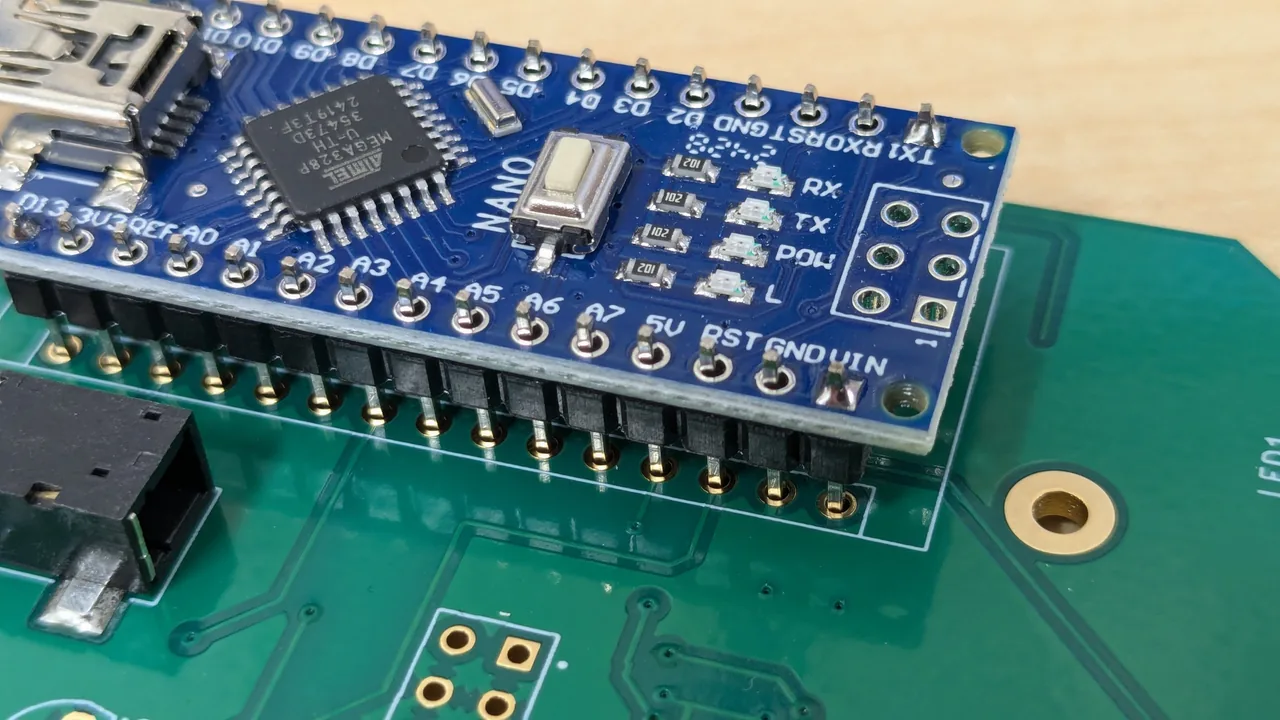 Top view of an Arduino Nano plugged into the board, with its pins lined up one by one