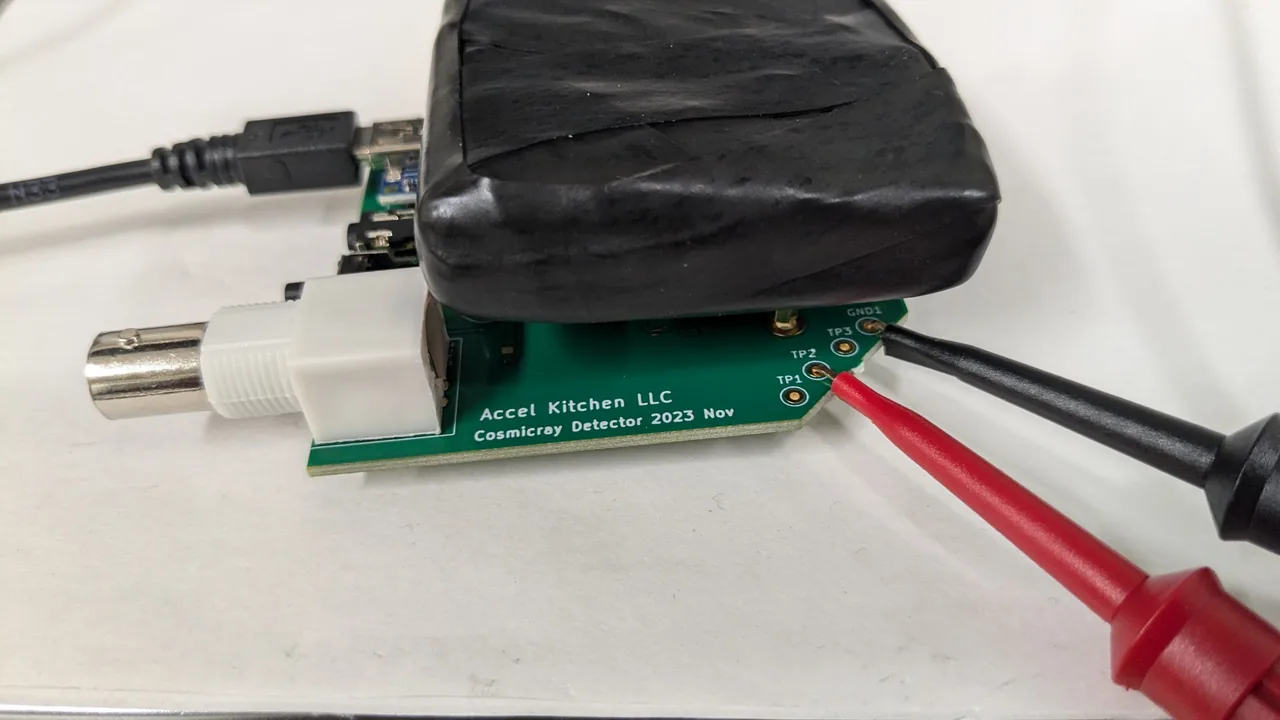 A board with red and black probe clips attached to the test points