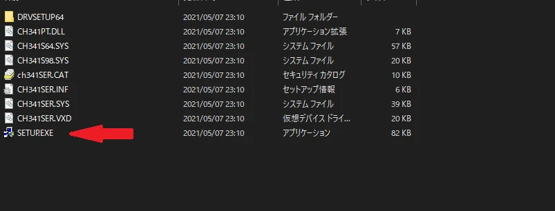 The contents of the extracted folder, with a red arrow pointing at SETUP.EXE