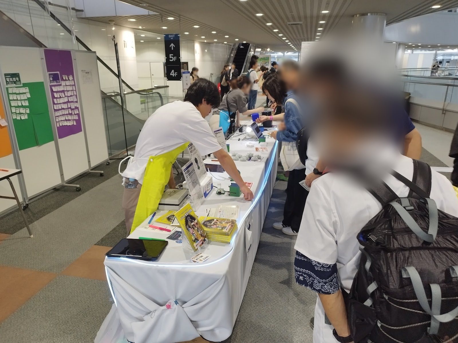 Visitors gathered at the booth with explainers helping them