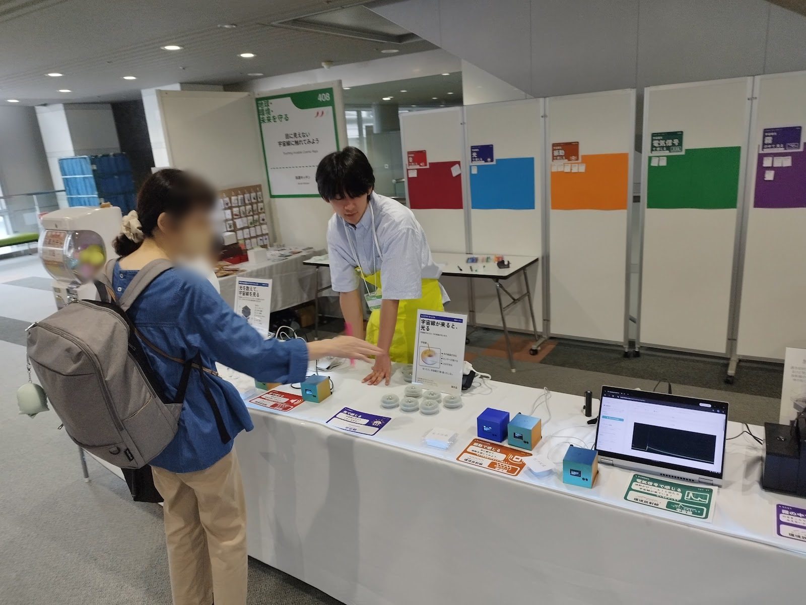 A visitor reaching towards the light device as an explainer describes it