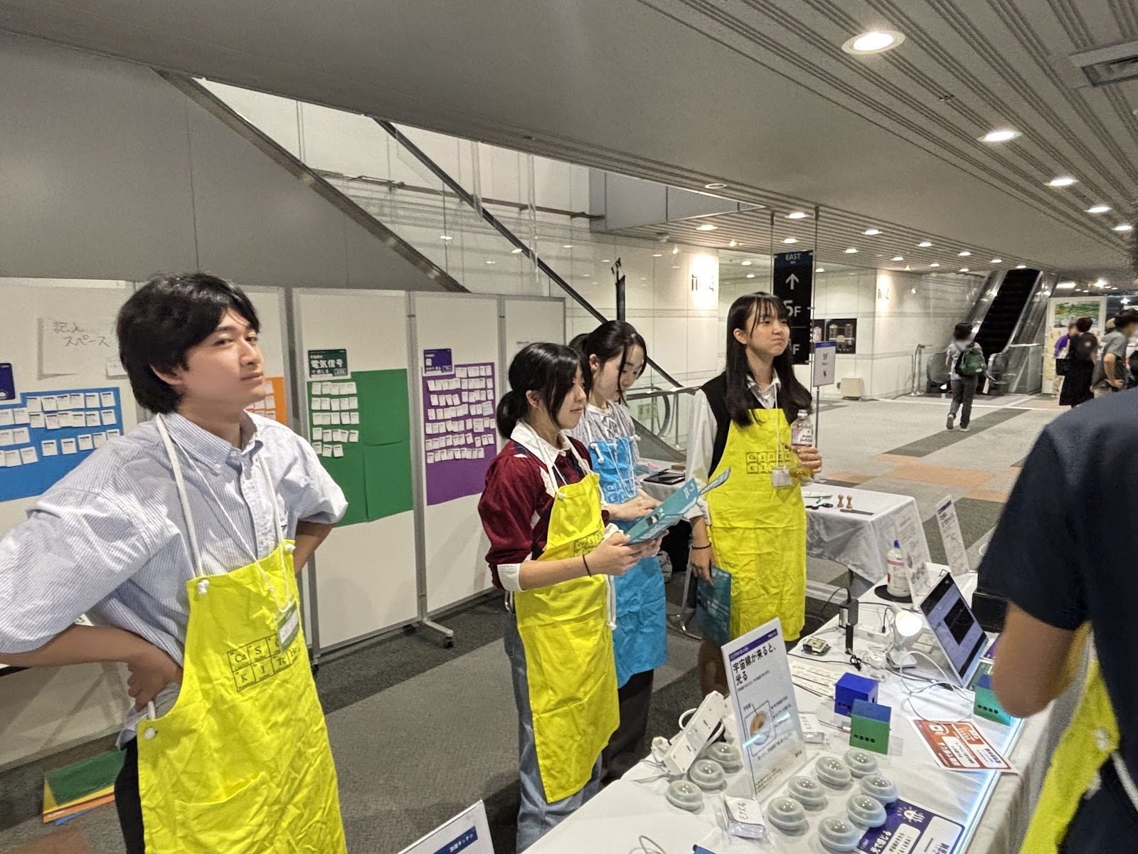 School students in aprons talking in front of the devices