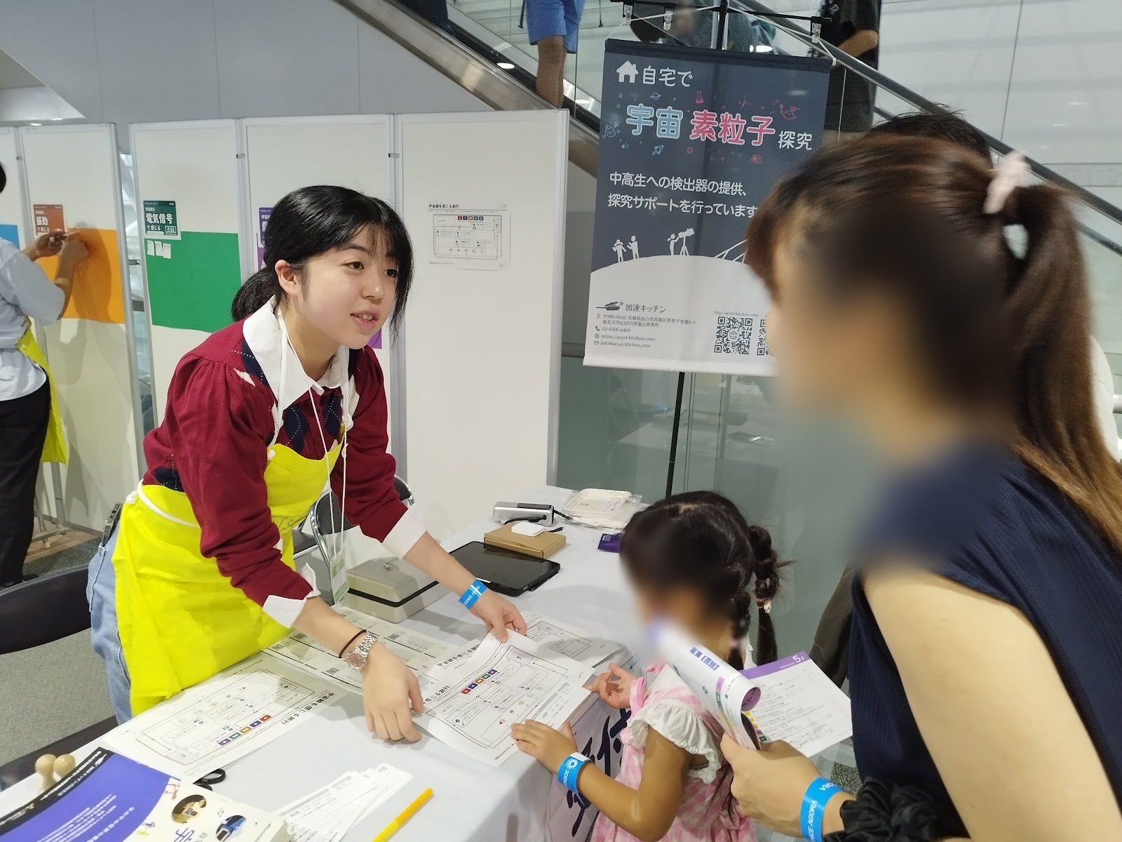 A student explaining the pass to a child and their parent