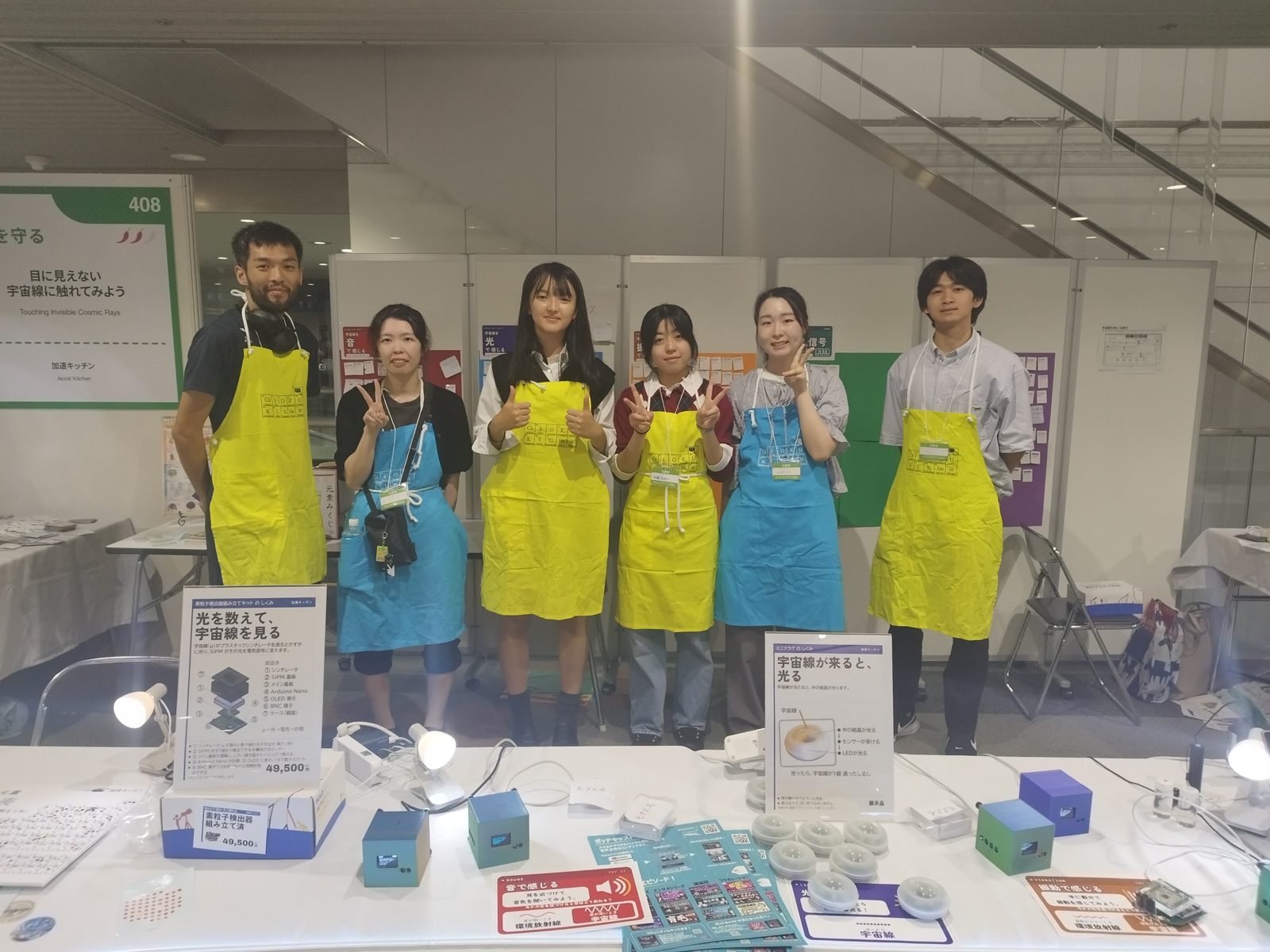 Six explainers in aprons standing in front of the booth