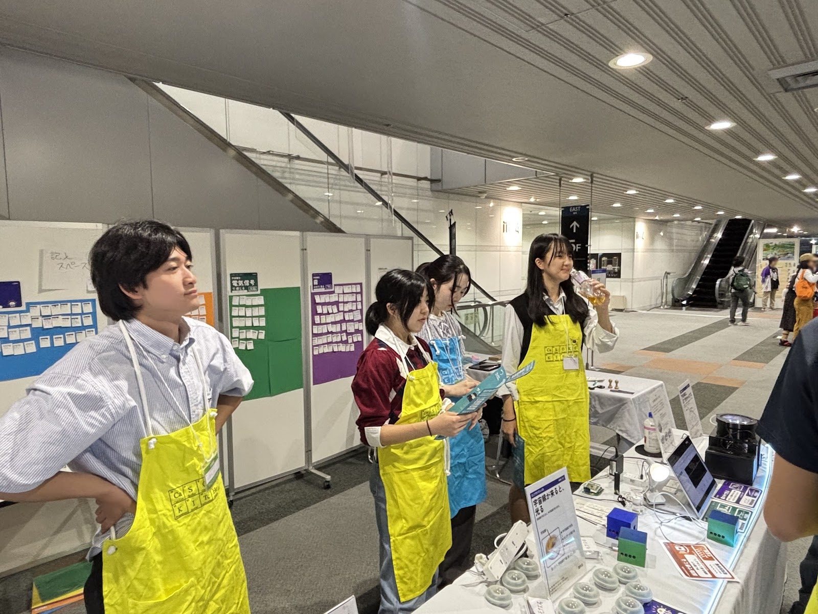 School students in aprons standing at the booth