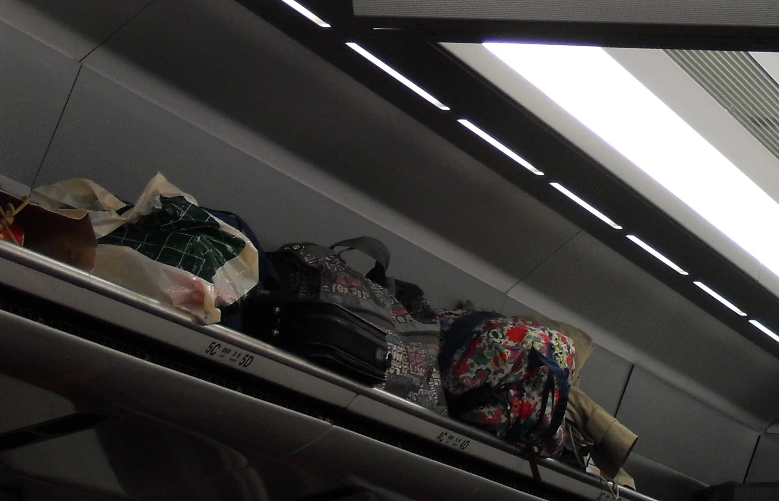 電車の網棚に置かれたたくさんの荷物