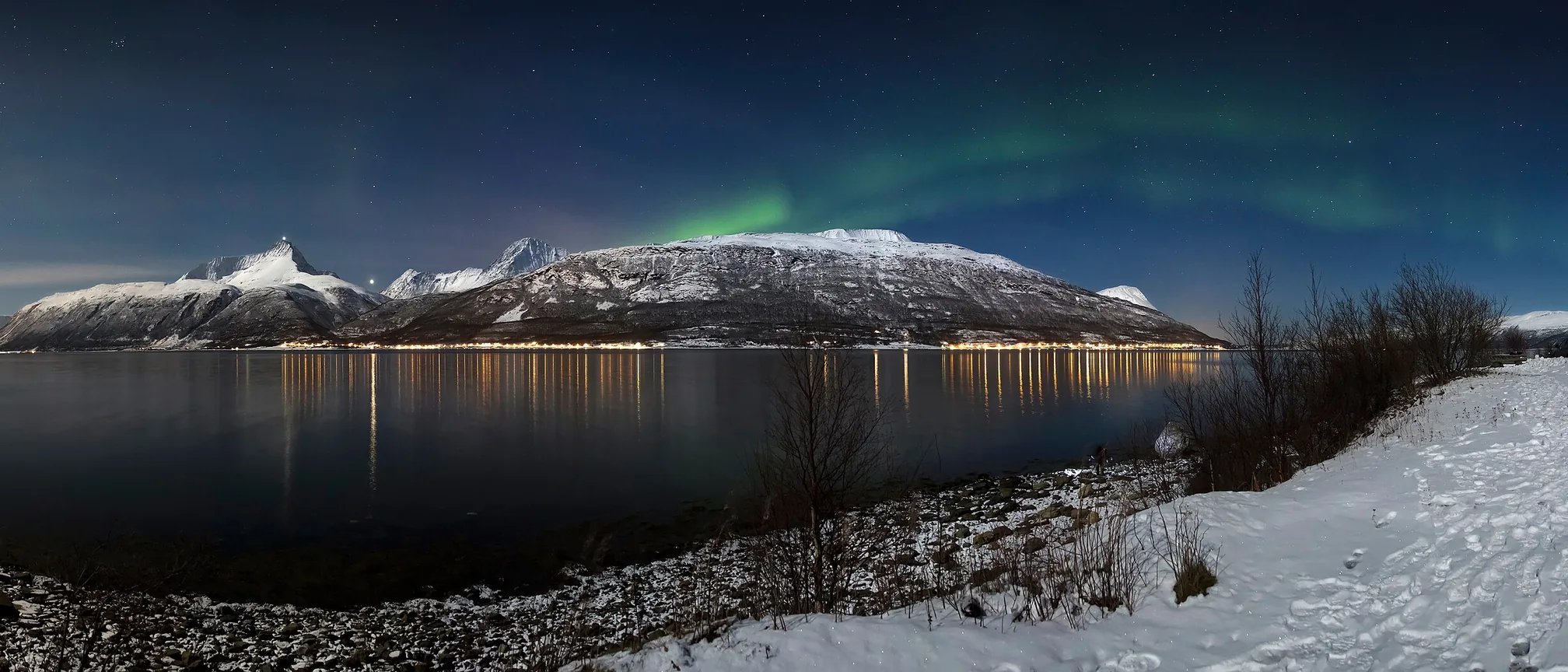 月明かりのノルウェー北部、リンゲン山脈とフィヨルドの夜空に広がるオーロラ
