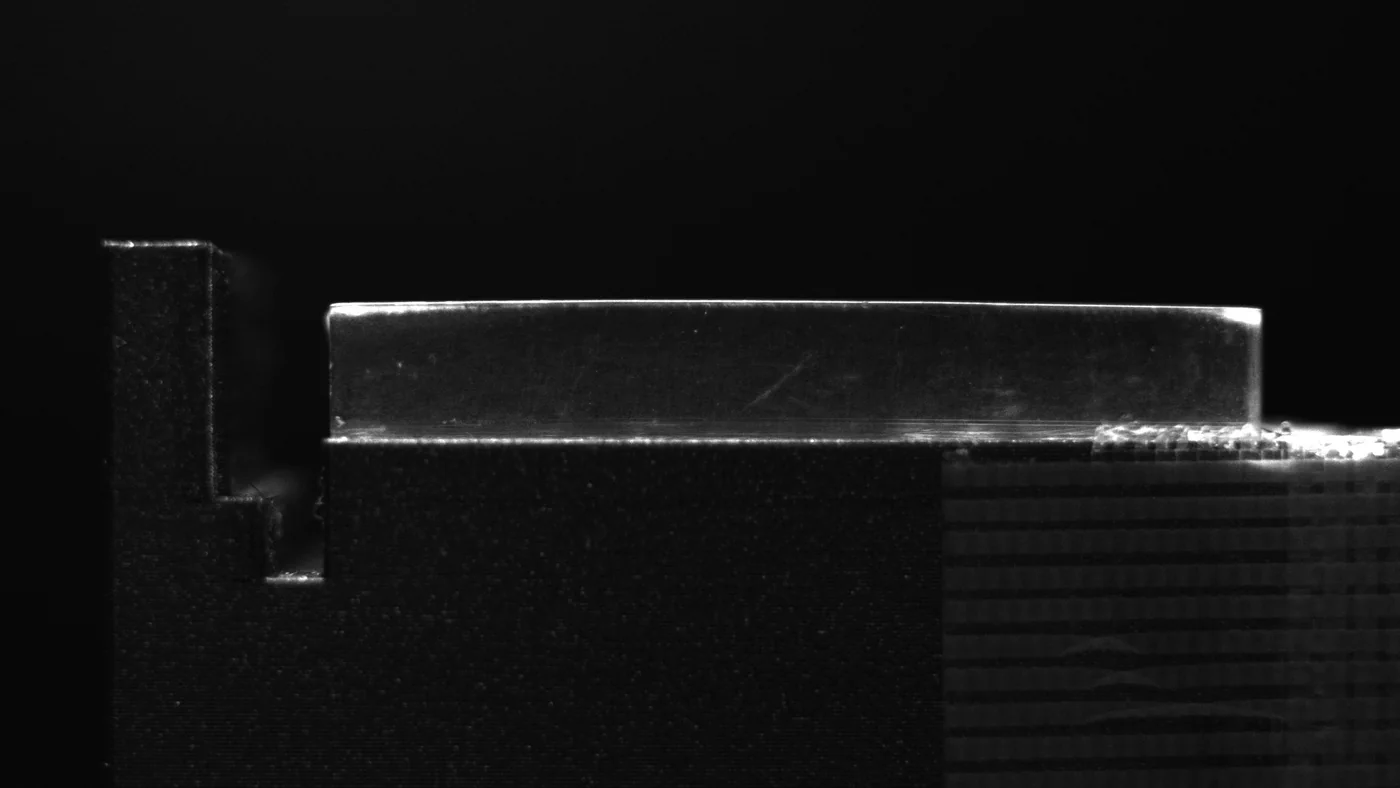 The CsI scintillator as the camera sees it under external light: a slender silver crystal resting on a dark stand